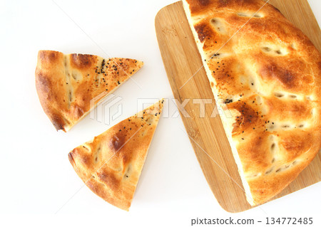 Slices of Ramadan Pita (Ramazan Pidesi) Traditional Turkish bread for holy month Ramadan on white background Slices of Ramadan Pita (Ramazan Pidesi) Traditional Turkish bread for holy month Ramadan on white background 134772485