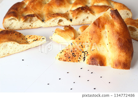 Slices of Ramadan Pita (Ramazan Pidesi) Traditional Turkish bread for holy month Ramadan on white background 134772486