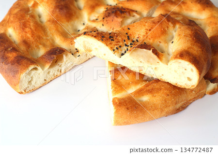 Slices of Ramadan Pita (Ramazan Pidesi) Traditional Turkish bread for holy month Ramadan on white background Slices of Ramadan Pita (Ramazan Pidesi) Traditional Turkish bread for holy month Ramadan on white background 134772487