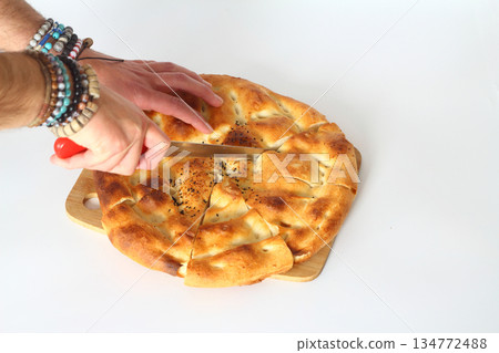 Slices of Ramadan Pita (Ramazan Pidesi) Traditional Turkish bread for holy month Ramadan on white background Slices of Ramadan Pita (Ramazan Pidesi) Traditional Turkish bread for holy month Ramadan on white background 134772488
