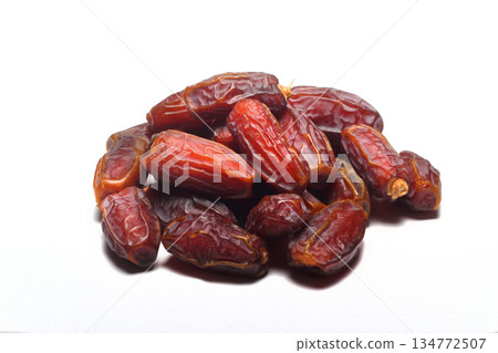Dates on a white background. Dried fruits. Dried dates lie next to each other Dates on a white background. Dried fruits. Dried dates lie next to each other 134772507