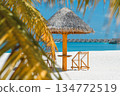 Luxury tropical resort with white sand beach, thatched umbrella and water villas over turquoise ocean 134772519