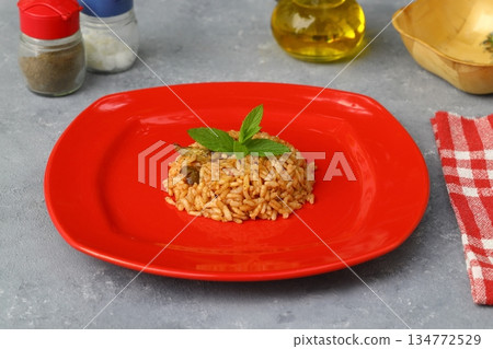 Turkish Stuffed Rice with Currants for Preparing Dolma in Plate with Spoon . Pilav or Pilaf 134772529