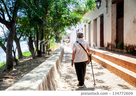 Senior travel concept. Senior woman walking at the beautiful streets of the colonial Heritage Town of Santa Cruz de Mompox in Colombia. 134772609