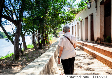 Senior travel concept. Senior woman walking at the beautiful streets of the colonial Heritage Town of Santa Cruz de Mompox in Colombia. 134772610