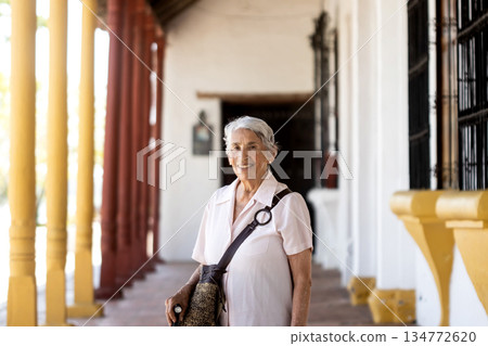 Senior travel concept. Senior woman tourist at the beautiful colonial Heritage Town of Santa Cruz de Mompox in Colombia. 134772620