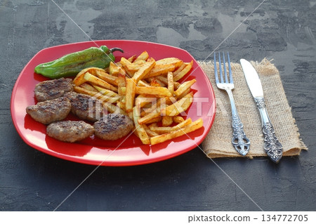 meatballs and potatoes on a red plate on black background meatballs and potatoes on a red plate on black background 134772705
