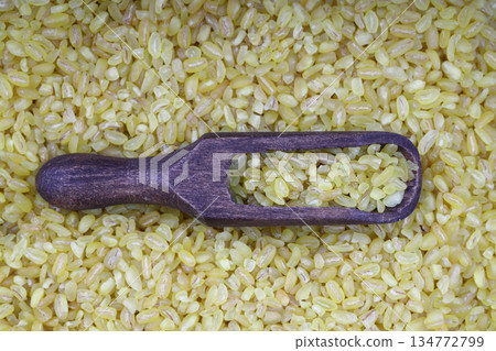 Dry bulgur wheat grains with a spoon close up Dry bulgur wheat grains with a spoon close up 134772799