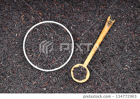 pile of black rice in a wooden bowl on a wooden table close-up pile of black rice in a wooden bowl on a wooden table close-up 134772903