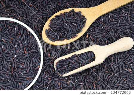 pile of black rice in a wooden bowl on a wooden table close-up 134772963