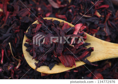 Karkade tea. Hibiscus tea leaves in wooden spoon isolated on white background. File contains clipping path. Top view. 134772976