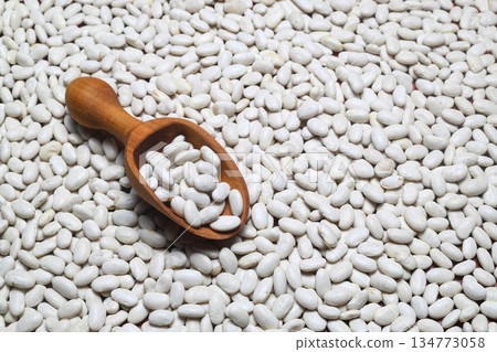 White Kidney beans scattered close-up with a scoop. 134773058