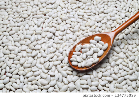 White Kidney beans scattered close-up with a spoon. 134773059