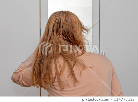 Woman styling hair Woman styling hair 134773152
