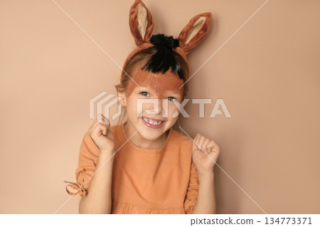 Funny laughing girl in a horse costume happily holds her fists, rejoicing at the approach of the new year 134773371