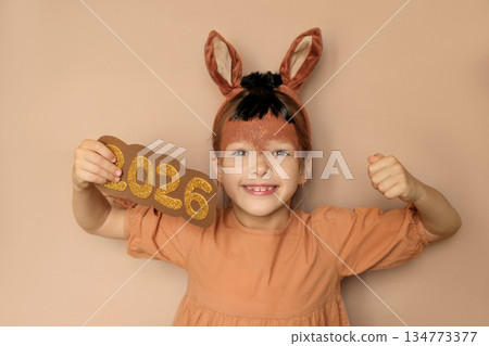 A child in the guise of a horse with a painted face rejoices at the arrival of the new year 2026. Zodiac sign according to the Eastern calendar 134773377