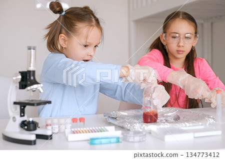 Children are conducting a scientific experiment to create volcanic foam. 134773412