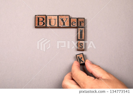 Buyer and Risk Concept with Wooden Letter Blocks on Gray Background Buyer and Risk Concept with Wooden Letter Blocks on Gray Background 134773541
