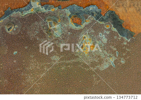 The image is of a rusty metal surface with a lot of holes and scratches The image is of a rusty metal surface with a lot of holes and scratches 134773712