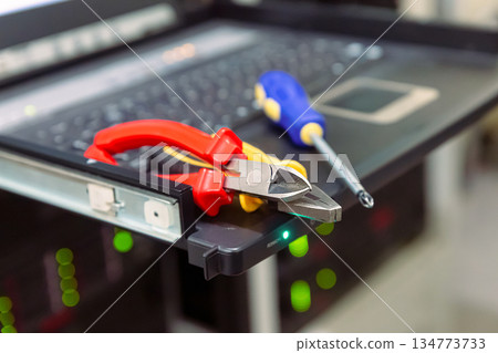 A pair of pliers and a screwdriver are on a laptop A pair of pliers and a screwdriver are on a laptop 134773733