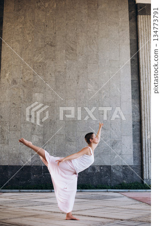 Female dancer performing contemporary movement outdoors 134773791