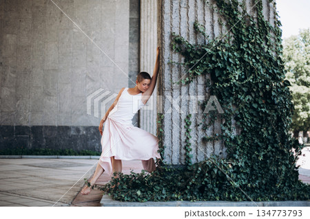 Woman expressing movement and emotion by stone column 134773793