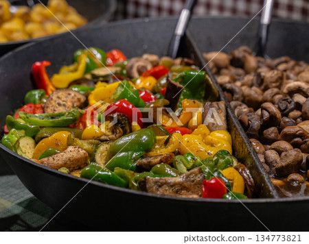 A black pan with a variety of vegetables and mushrooms A black pan with a variety of vegetables and mushrooms 134773821