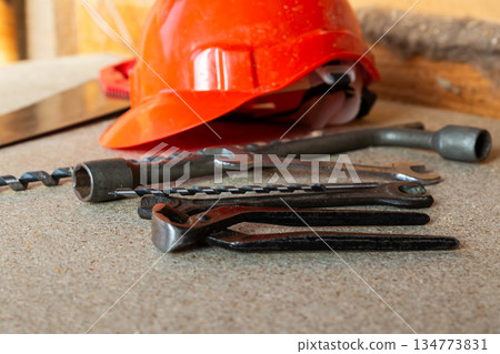 Red helmet and various tools lie on a neutral background Red helmet and various tools lie on a neutral background 134773831