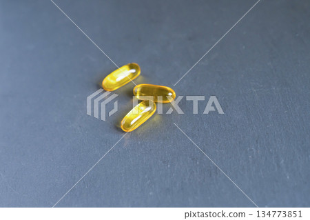 3 yellow tablets vitamins omega 3 6 9 in capsule form lie on a neutral background 134773851