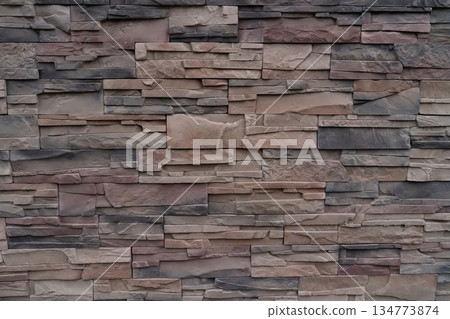 A wall made of stone blocks with a brown and gray color 134773874