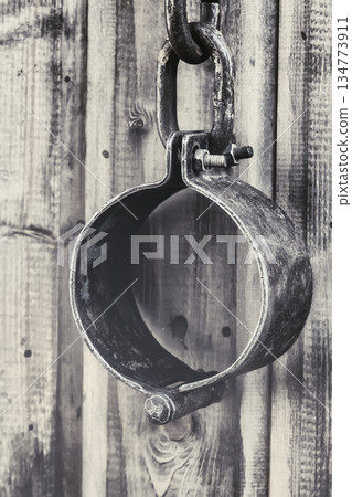 old and rusty shackles closed traditional design handcuffs hanging on a wall background old and rusty shackles closed traditional design handcuffs hanging on a wall background 134773911