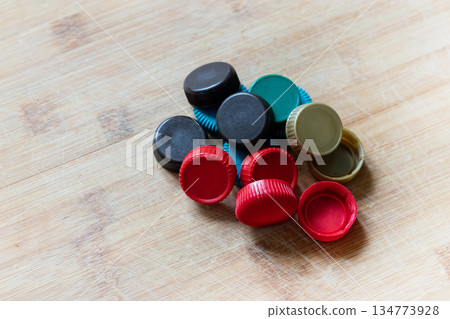 A bunch of colorful caps are piled on a wooden table A bunch of colorful caps are piled on a wooden table 134773928