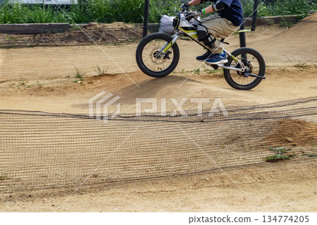 一名8歲男孩在越野摩托車賽道上騎自行車 一名8歲男孩在越野摩托車賽道上騎自行車 134774205