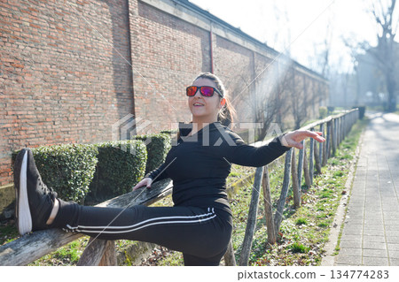 Woman with visual disabilities exercising in the park and stretching Woman with visual disabilities exercising in the park and stretching 134774283