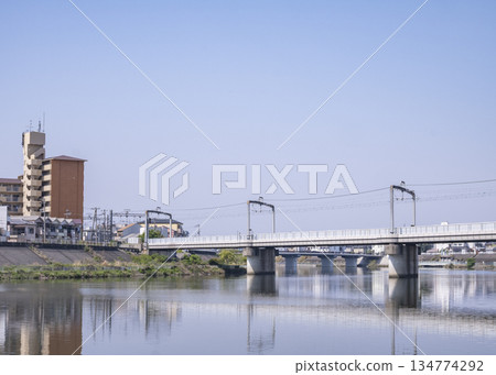 橋樑和建築物倒映在河面上，形成一幅平靜如鏡的景象。 134774292
