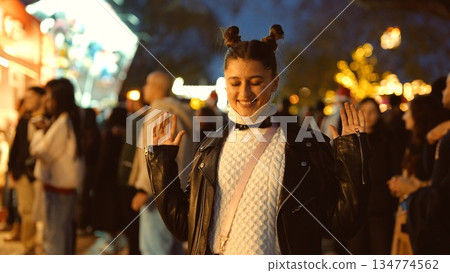 Youthful woman smiles amid vibrant market atmosphere at night Youthful woman smiles amid vibrant market atmosphere at night 134774562