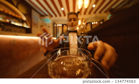 Man reaches out to grip his nearby beer mug enthusiastically Man reaches out to grip his nearby beer mug enthusiastically 134774563