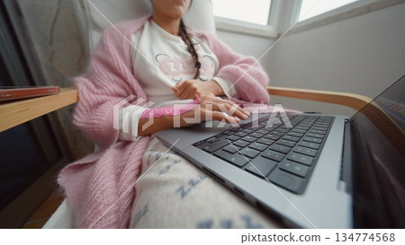 Young female engaging with multiple gadgets in moody pink lighting Young female engaging with multiple gadgets in moody pink lighting 134774568