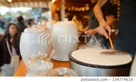 vendor serves finished crepe on porcelain plate to customer vendor serves finished crepe on porcelain plate to customer 134774619
