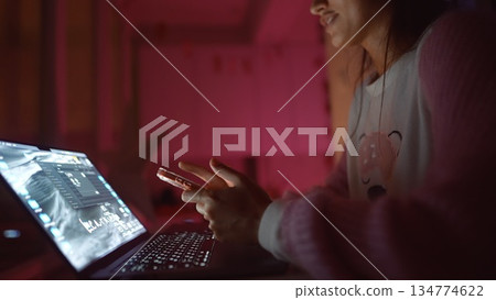 Female presenter instructing audience via illuminated laptop display 134774622