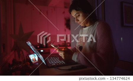 Relaxed woman smiling during evening online messaging session 134774624