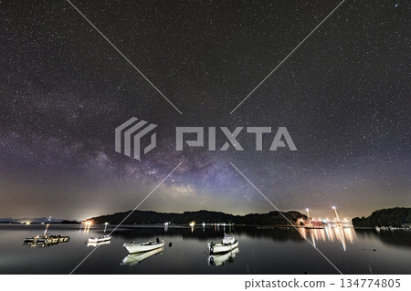Spring starry scenery in Setouchi: The Milky Way rising in the sky above a fishing port 134774805