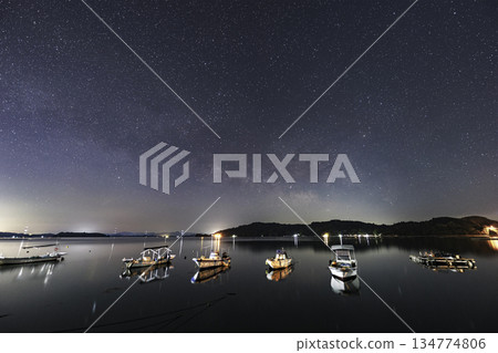 Spring starry scenery in Setouchi: The Milky Way rising in the sky above a fishing port 134774806