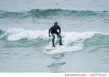 Surfer riding waves 134775319
