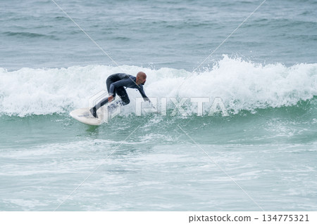 Surfer riding waves 134775321