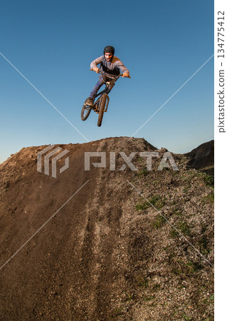 BMX Bike jump over a dirt trail BMX Bike jump over a dirt trail 134775412