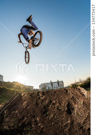 BMX Bike jump over a dirt trail BMX Bike jump over a dirt trail 134775417