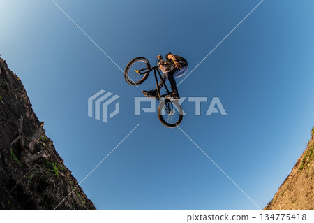 BMX Bike jump over a dirt trail BMX Bike jump over a dirt trail 134775418