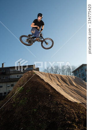 BMX Bike jump over a dirt trail BMX Bike jump over a dirt trail 134775420