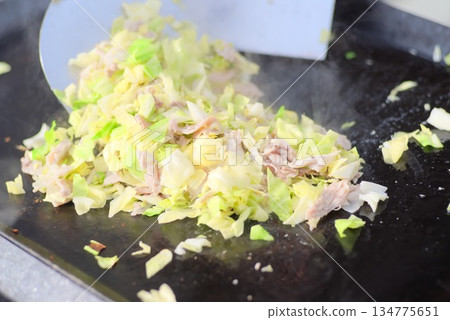 炒麵用的高麗菜和豬肉正在熱板上翻炒。 炒麵用的高麗菜和豬肉正在熱板上翻炒。 134775651